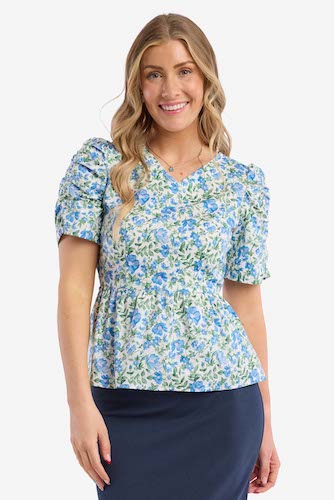 Woman wearing a blue and white floral top with puff sleeves