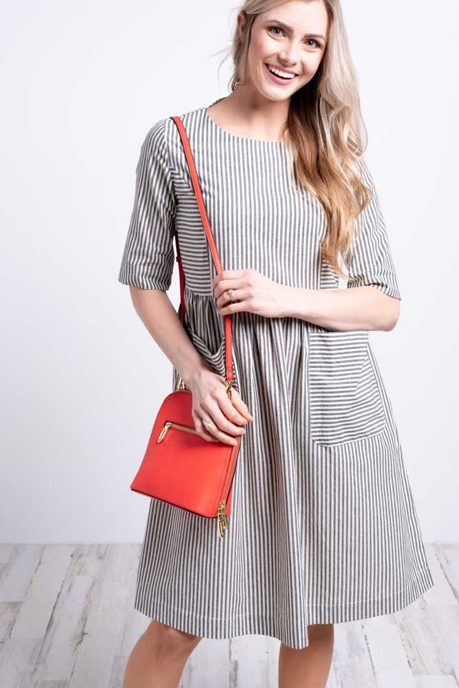 Woman in striped dress with red crossbody bag