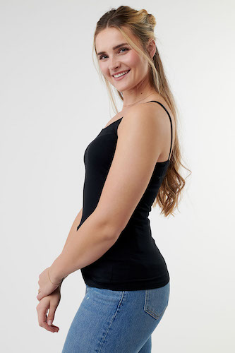Woman wearing a black camisole with blue jeans