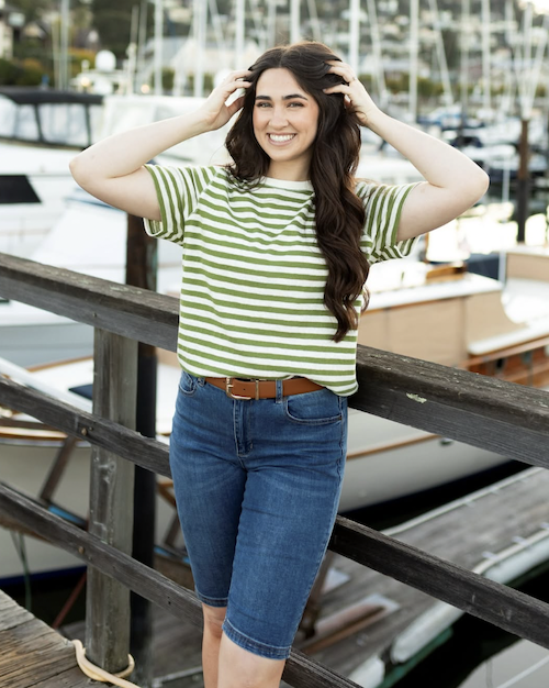 Woman wearing a striped tee and bermuda shorts on a boat dock